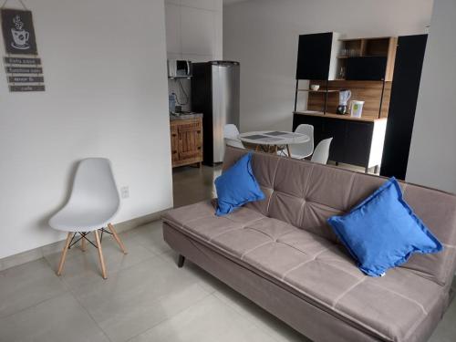 a living room with a couch with two blue pillows at Casa Premium em Bonito - Linda e Confortável in Bonito