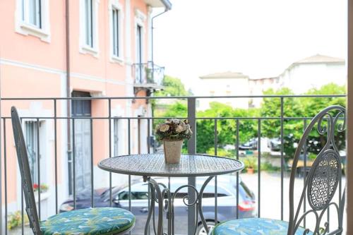 una mesa con un jarrón de flores en el balcón en Bilo Via Bellinzona, en Como