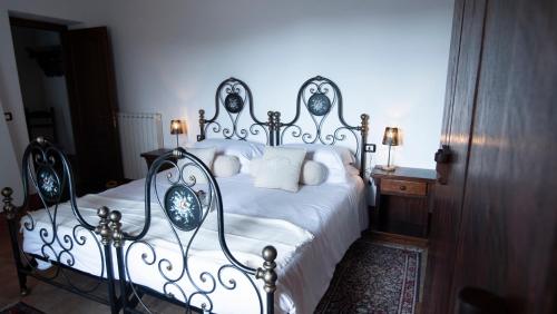 a bedroom with a large bed with white sheets at I Salici Agriturismo in Badia Agnano