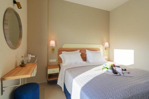 a bedroom with a bed and a table and a mirror at Vakakis Family Luxury Studios 2 in Palaiochóra