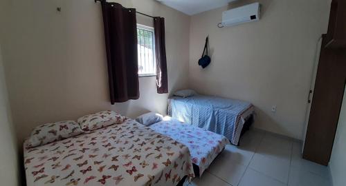 um pequeno quarto com uma cama e uma janela em Casa em barreirinhas em Barreirinhas