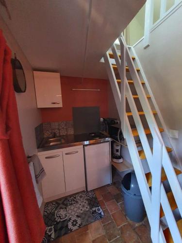 une petite cuisine avec un escalier menant à une chambre dans l'établissement Four à pain, à Torcé-en-Charnie