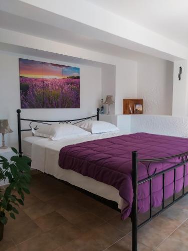 une chambre avec un grand lit avec une couverture violette dans l'établissement Etoilevacances Chambres d hotes Campagne en Lavande, à Les Veyans