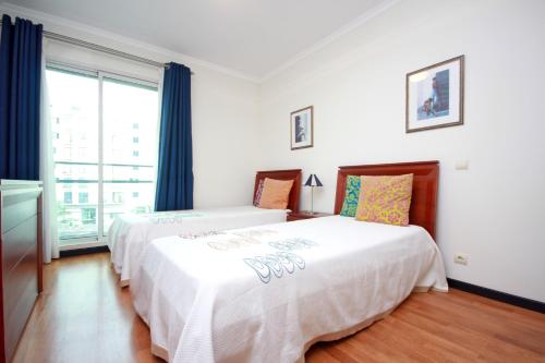 フンシャルにあるForum Apartment by HR Madeiraのベッドルーム1室(ベッド1台、大きな窓付)