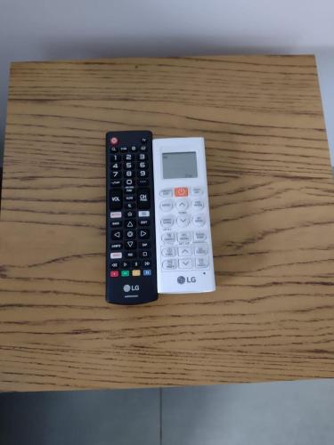 two remote controls sitting on top of a wooden table at Casa Premium em Bonito - Linda e Confortável in Bonito