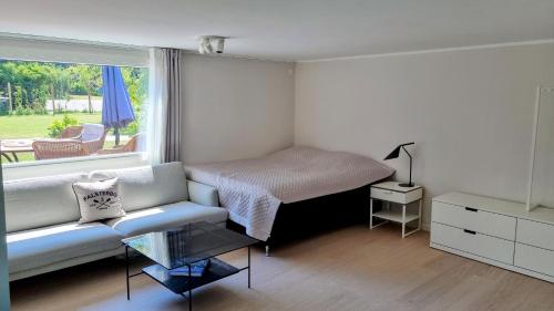 ein Schlafzimmer mit einem Bett, einem Sofa und einem Fenster in der Unterkunft Falsterbo Guesthouse - Modern & Comfy in Skanör med Falsterbo