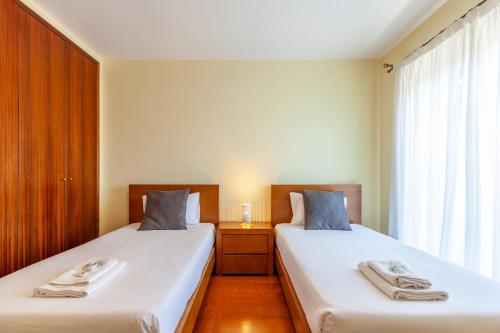 a bedroom with two beds and a window at Casa Faria da Costa in Esposende