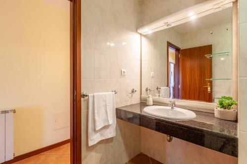 a bathroom with a sink and a mirror at Casa Faria da Costa in Esposende