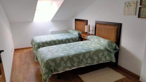 a room with two beds and a wooden floor at La casa de Yeico in Puebla de Lillo