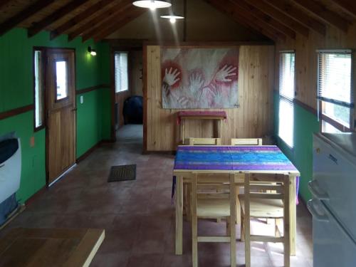 uma sala de jantar com uma mesa e algumas paredes verdes em Casa al Río em El Chaltén