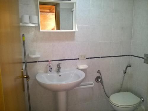 a bathroom with a sink and a toilet and a mirror at Il Gabbiano blu - Monolocale Blu in Marettimo