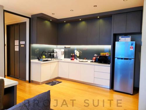 a kitchen with white cabinets and a blue refrigerator at Brojat Suite Family City View @ Imperium Residence in Kuantan