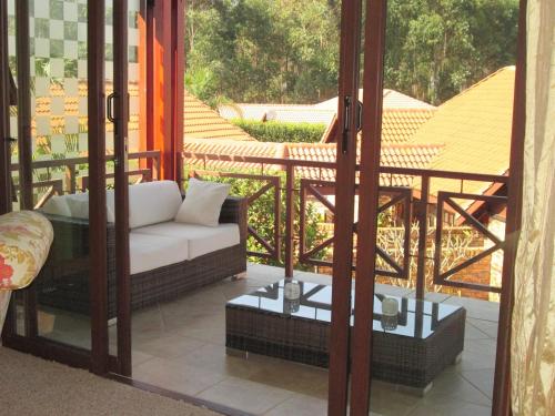 a balcony with a couch and a table on a porch at Schneiders Boutique Hotel in White River