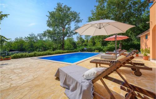 een patio met een tafel, een parasol en een zwembad bij Lovely Home In Sv,lovrec With Kitchen in Stifanići