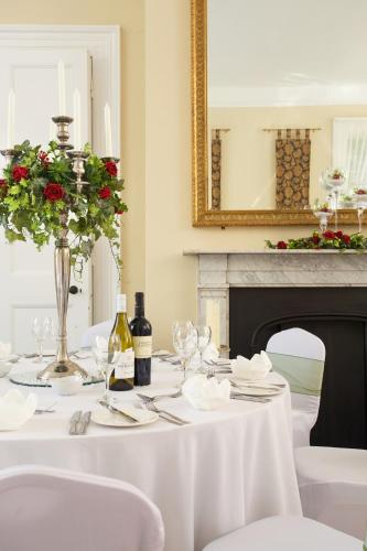 a white table with white chairs and a fireplace at The Queen's Inn in Hawkhurst
