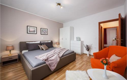 a bedroom with a bed and an orange chair at Lovely Home In Sv,lovrec With Kitchen in Stifanići