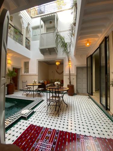 a living room with a pool and tables in a building at Riad Magnolia & SPA in Marrakech