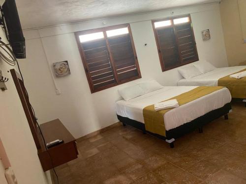 um quarto com 2 camas e 2 janelas em Hotel Villa Chic em Progreso