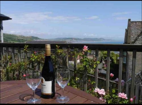 a bottle of wine and two wine glasses on a table at Fantastic spacious house with beautiful panoramic views of the bay Only a few minutes walk from beach harbour and restaurants This house has 3 bedrooms 3 bathrooms and 2 lovely sitting rooms in Lyme Regis