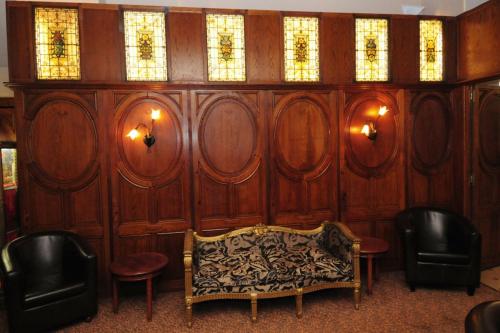 a room with a couch and chairs and windows at Hôtel Aletti Palace in Vichy