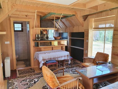 ein Zimmer mit einem Tisch und Stühlen in einer Hütte in der Unterkunft Planinska koliba Ajdanovici Jelovac Nisicka visoravan in Olovo