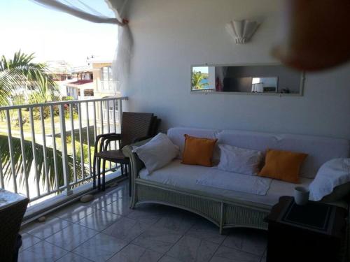 a living room with a couch on a balcony at Just in paradise in Baie Nettle