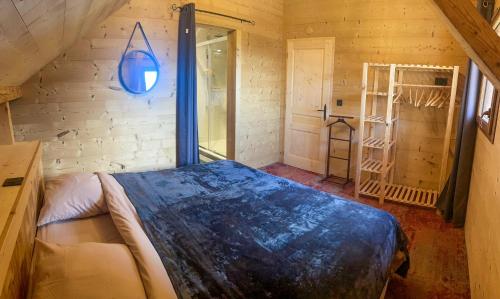 a bedroom with a bed in a wooden room at La Ferme De L'âne Rouge 7 nuits minimum in Bernex