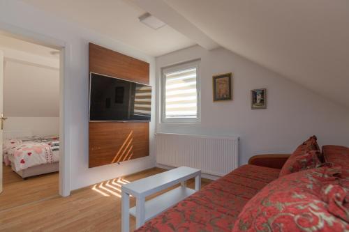 a living room with a couch and a tv and a bedroom at Vikendica ''CASA DE TARA'' - Planina Tara in Kaludjerske Bare