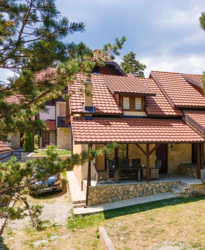 a house with a red roof and a yard at Vikendica ''CASA DE TARA'' - Planina Tara in Kaludjerske Bare