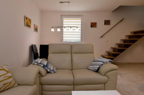 a living room with a couch and a staircase at Vikendica ''CASA DE TARA'' - Planina Tara in Kaludjerske Bare