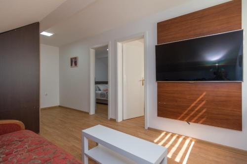 a living room with a large flat screen tv on a wall at Vikendica ''CASA DE TARA'' - Planina Tara in Kaludjerske Bare