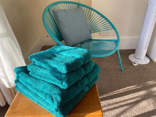 a blue chair with a pile of towels on a table at Bon-Ami in Lowestoft