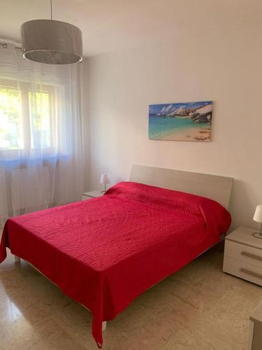 1 dormitorio con 1 cama roja en una habitación blanca en CASA VACANZE RE DEL MARE en Taranto