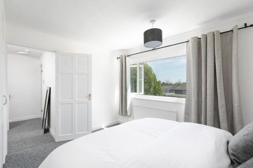 um quarto com uma cama branca e uma janela em Parkside House em Stevenage