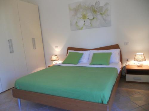 CampofiloneにあるLa casa di Tamaraのベッドルーム1室(大型ベッド1台、緑の枕2つ付)