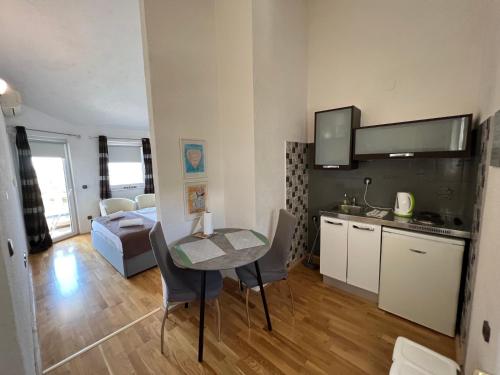 cocina y sala de estar con mesa y sillas en Apartmani Levarda, en Trogir