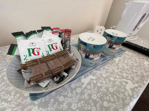 une table avec une assiette de nourriture et quelques tasses dans l'établissement Bon-Ami, à Lowestoft