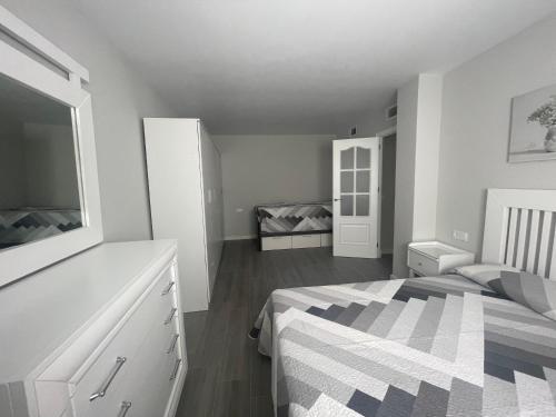 een witte slaapkamer met een bed en een dressoir bij Nuevo Azorin I in Conil de la Frontera