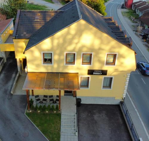 an overhead view of a yellow house with a roof at Apartmani Brko in Kotor-Varoš