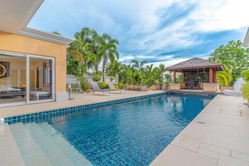 an image of a swimming pool in a house at Pattaya Luxury 4BR Pool Villa-BBQ, Karaoke & Pool Table for Families & Group of Travellers in Nong Prue