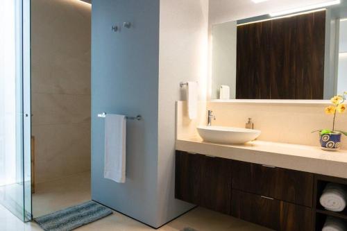 y baño con lavabo y espejo. en Luxury Oceanview Modern Condo, en Puerto Vallarta
