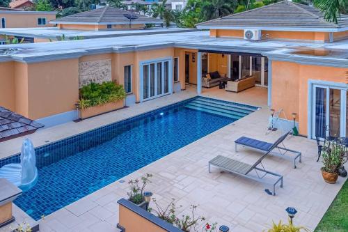 a swimming pool in the backyard of a house at Pattaya Luxury 4BR Pool Villa-BBQ, Karaoke & Pool Table for Families & Group of Travellers in Nong Prue