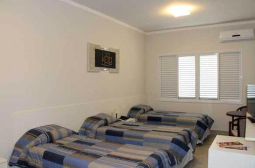 a bedroom with two beds and a table at Habitat Prime Hotel in Leme