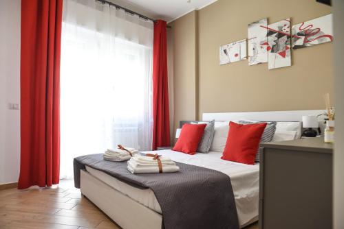 a bedroom with a bed with red curtains and a window at La casetta di Lulù in Nettuno