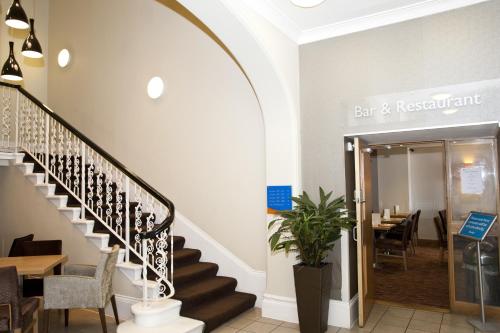 a restaurant with stairs leading to a dining room at Shore View Hotel in Eastbourne