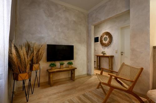 een woonkamer met een flatscreen-tv aan de muur bij The In Town Apartment - With a Private Terrace in Corfu-stad