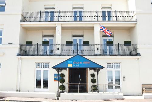 a building with a blue awning and an american flag at Shore View Hotel in Eastbourne
