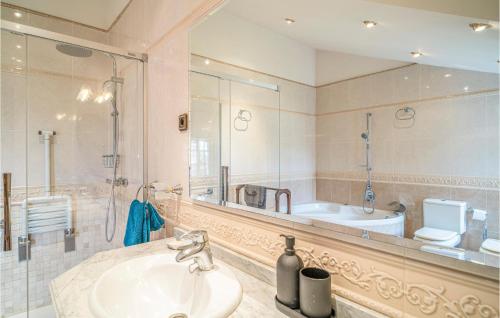 een badkamer met een wastafel, een bad en een spiegel bij Amazing Home In Las Lagunas De Mijas With Swimming Pool in Santa Fe de los Boliches
