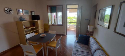 a living room with a couch and a table and chairs at Casa degli Oleandri in Santa Caterina