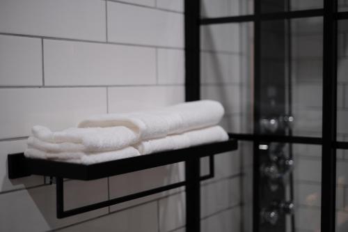 a pile of towels on a shelf in a bathroom at Stunning exec spa retreat w/panoramic lake views! in Haslett